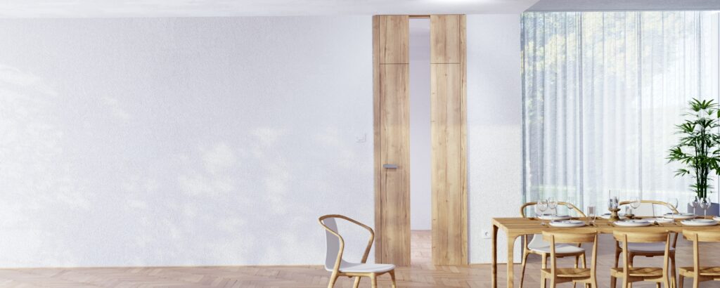 Eine moderne deckenbündige Innentür mit rustikaler Holzoberfläche und einem Glasinlay in einem Esszimmer mit Rauputzwand und warmem, stilvollen Ambiente von WIENTÜR91.