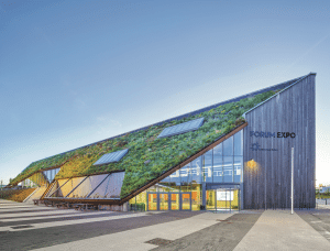ZinCo zeigt eine moderne Messehalle mit schrägem Dach und Dachbegrünung.