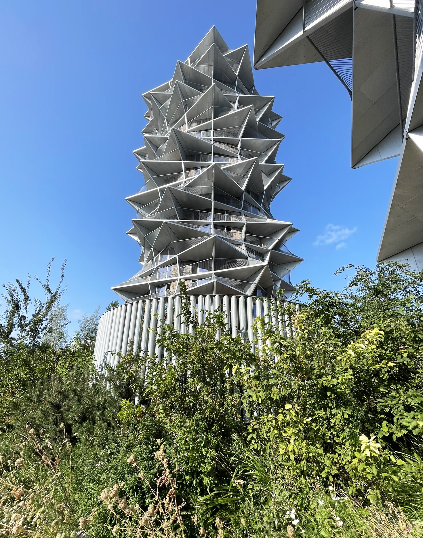 Zinco präsentiert das Projekt Kaktus Tower in Kopenhagen mit einem vorgelagerten Hang mit Stauden, Sträuchern und Bäumen.