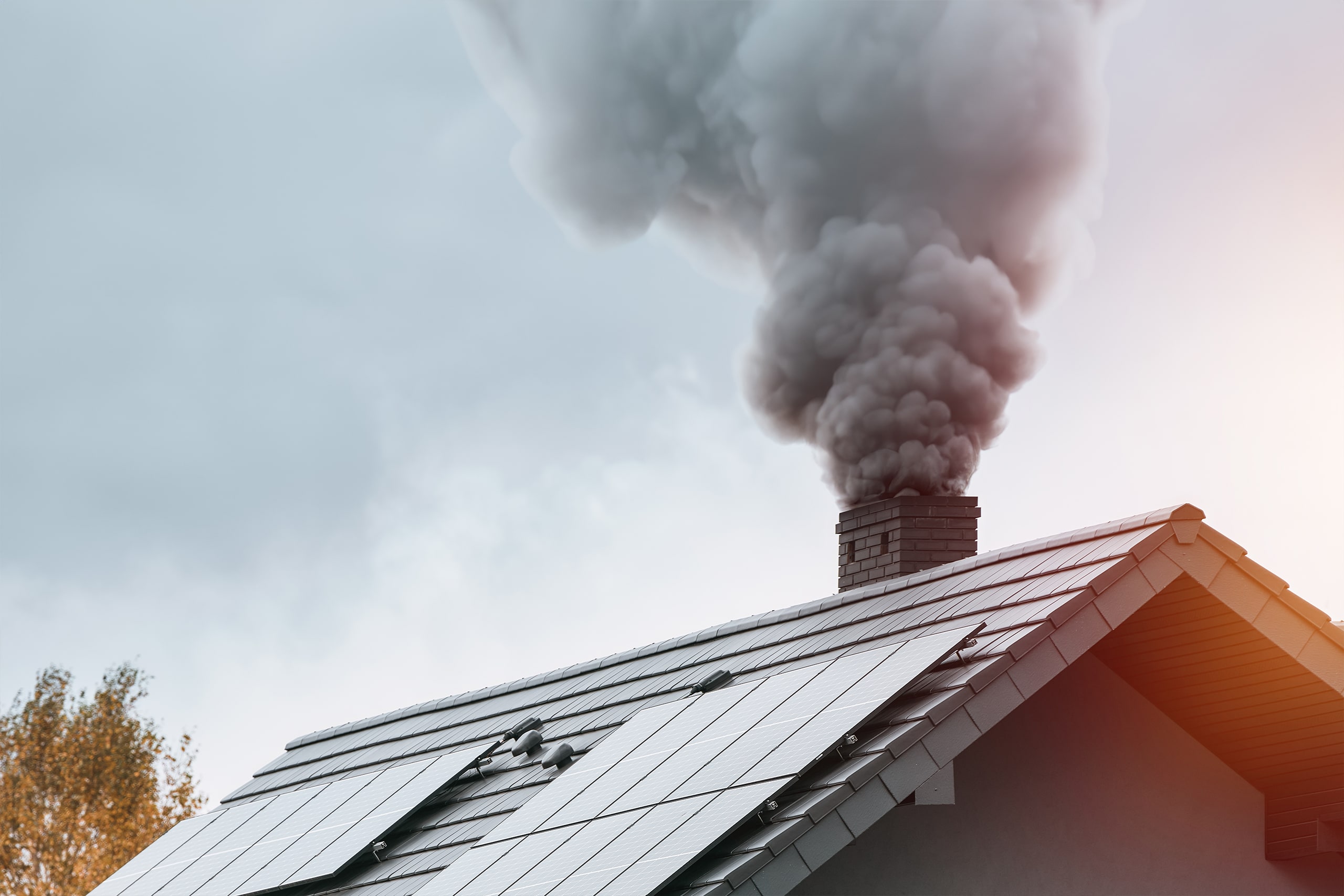 Im Winter stößt ein modernes Haus schwarzen Rauch aus dem Schornstein aus, was zu Umweltverschmutzung und globaler Erwärmung beiträgt. Der schwarze Rauch aus dem Schornstein eines Hauses auf dem Land verdeutlicht die Auswirkungen des Heizens. Der schwarzen Rauch entsteht durch fehlerhaftes Heizen und Versottung des Heizrohres.