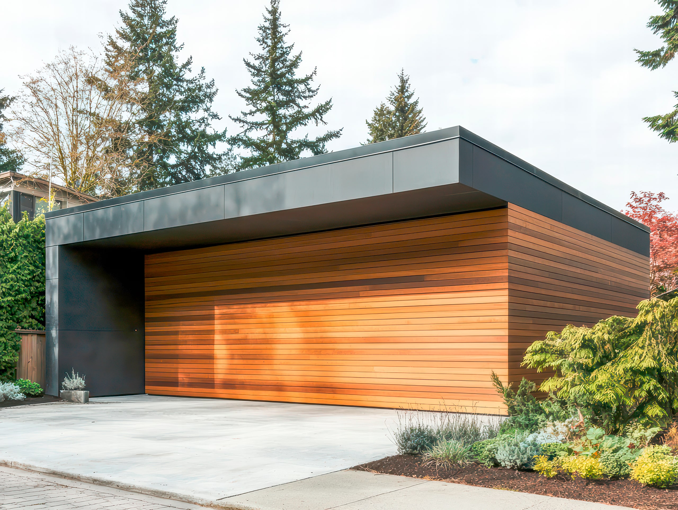 Freistehende, moderne Garage mit Flachdach, horizontaler Zedernholzverkleidung an der Fassade, einem breiten, fassadenbündigen Holztor, das unsichtbar erscheint.