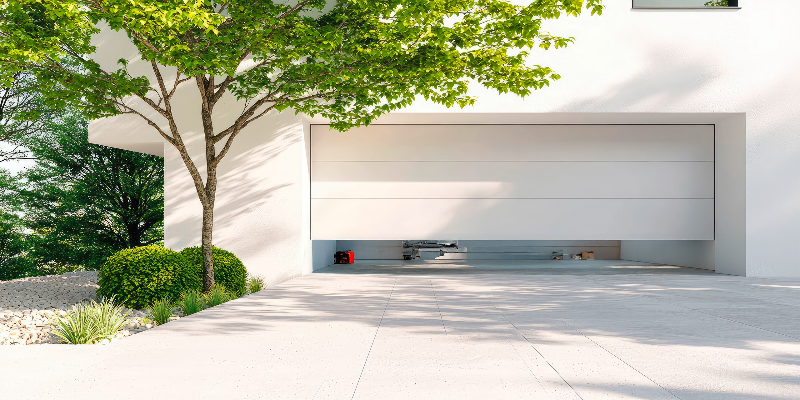 Modernes, automatisches Garagentor in weiß, mit Blick in das Innere der Garage.