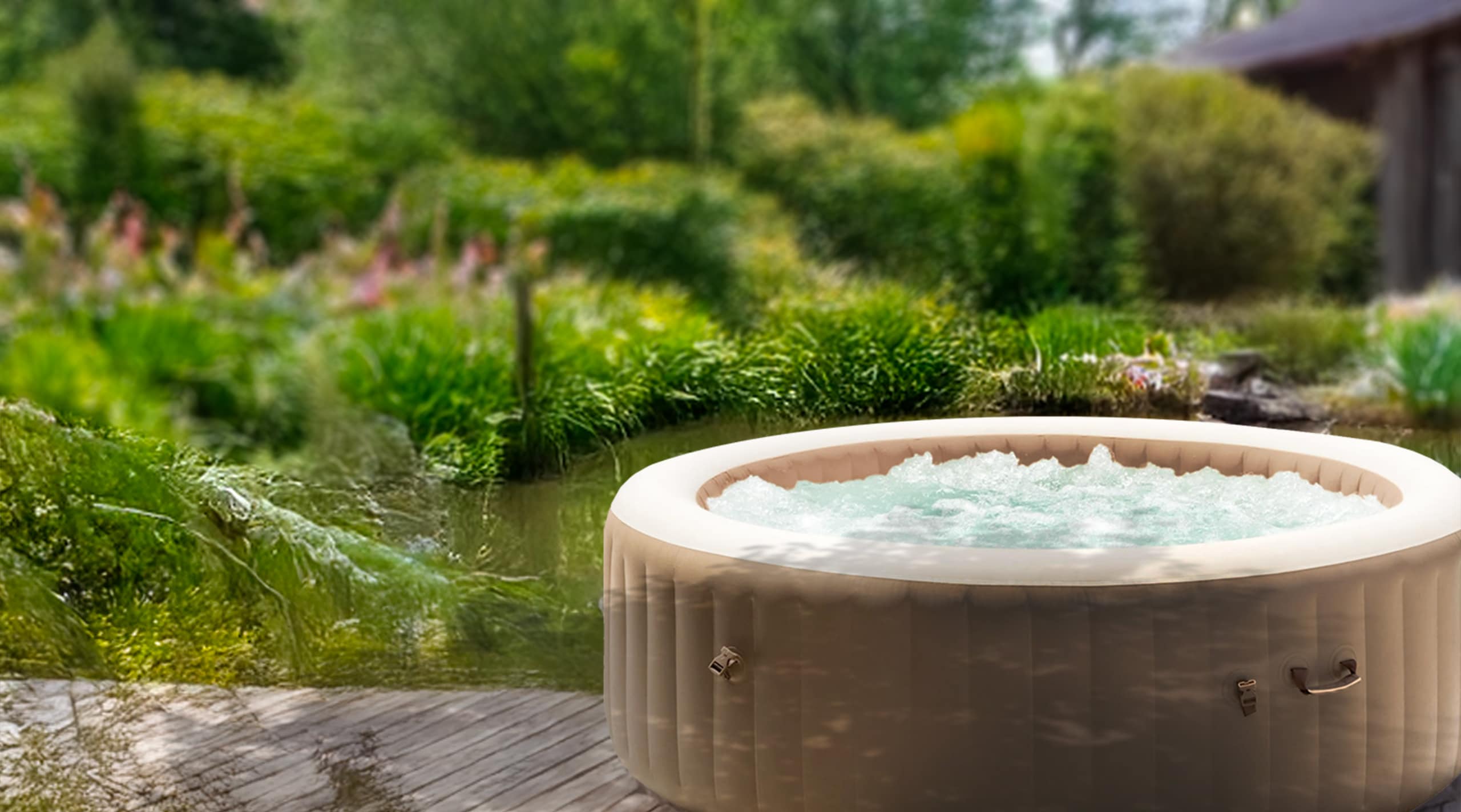 Aufblasbarer Aussen-Whirlpool mit sprudelndem Wasser in einem naturbelassenem Garten am ende eines Holzsteges eines Teiches, im Hintergrund eine kleine Holzhütte.