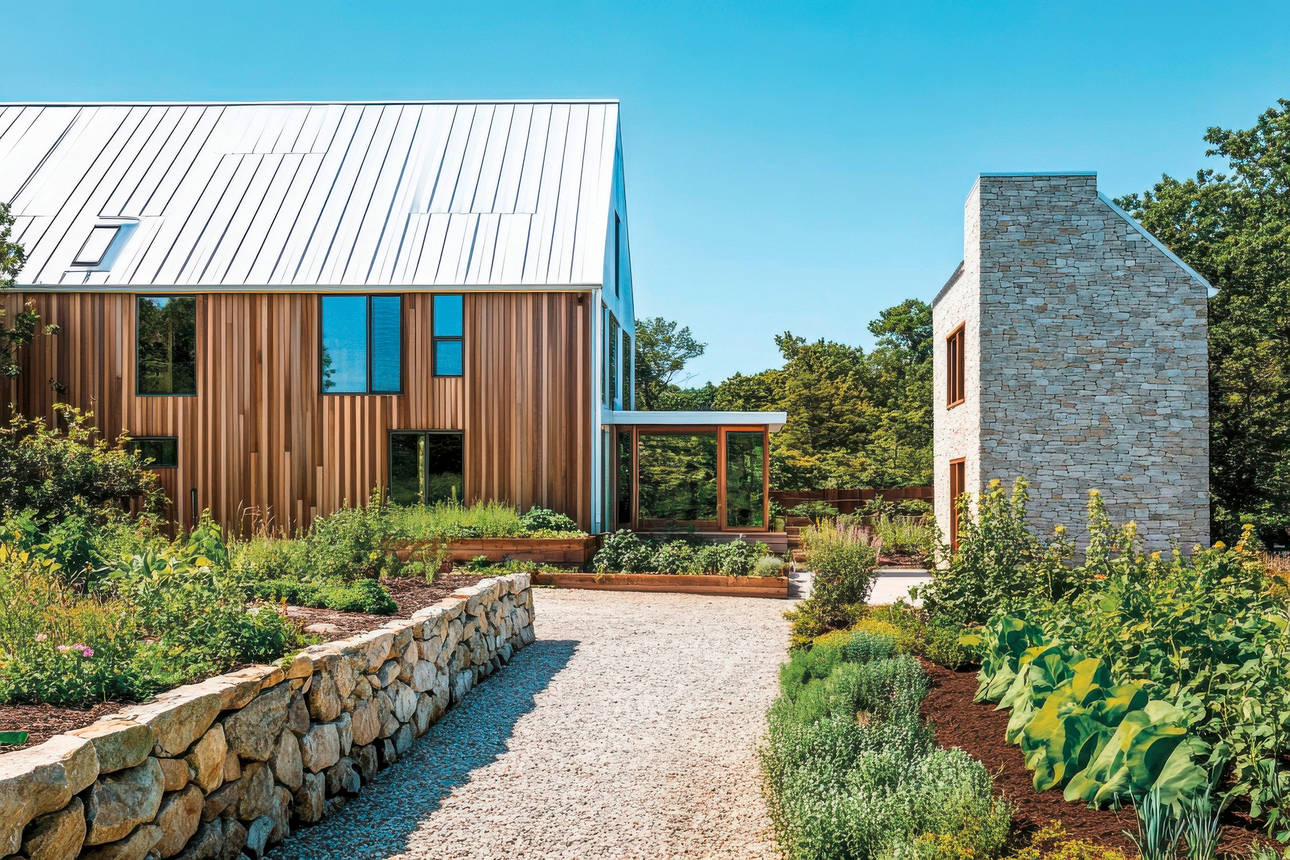 Modernes Holzhaus besticht durch sein kantiges Design und große Glasfenster. Es liegt in einer ruhigen Gegend mit üppigen Rasenflächen und altem Baumbestand unter strahlend blauem Himmel.
