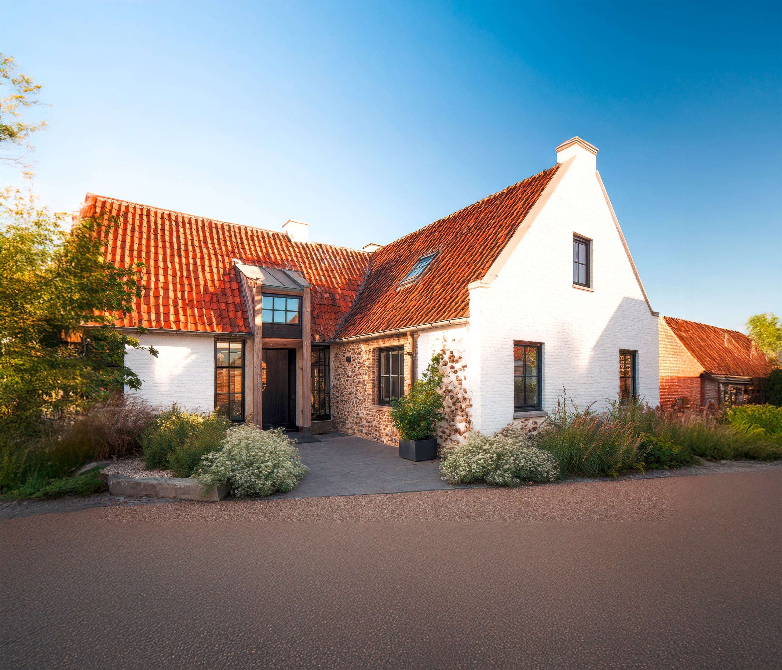 Charmantes, modernes Cottage mit rustikaler Backsteinfassade, eingebettet in üppiges Grün an einem sonnigen Nachmittag in einer ruhigen Nachbarschaft.