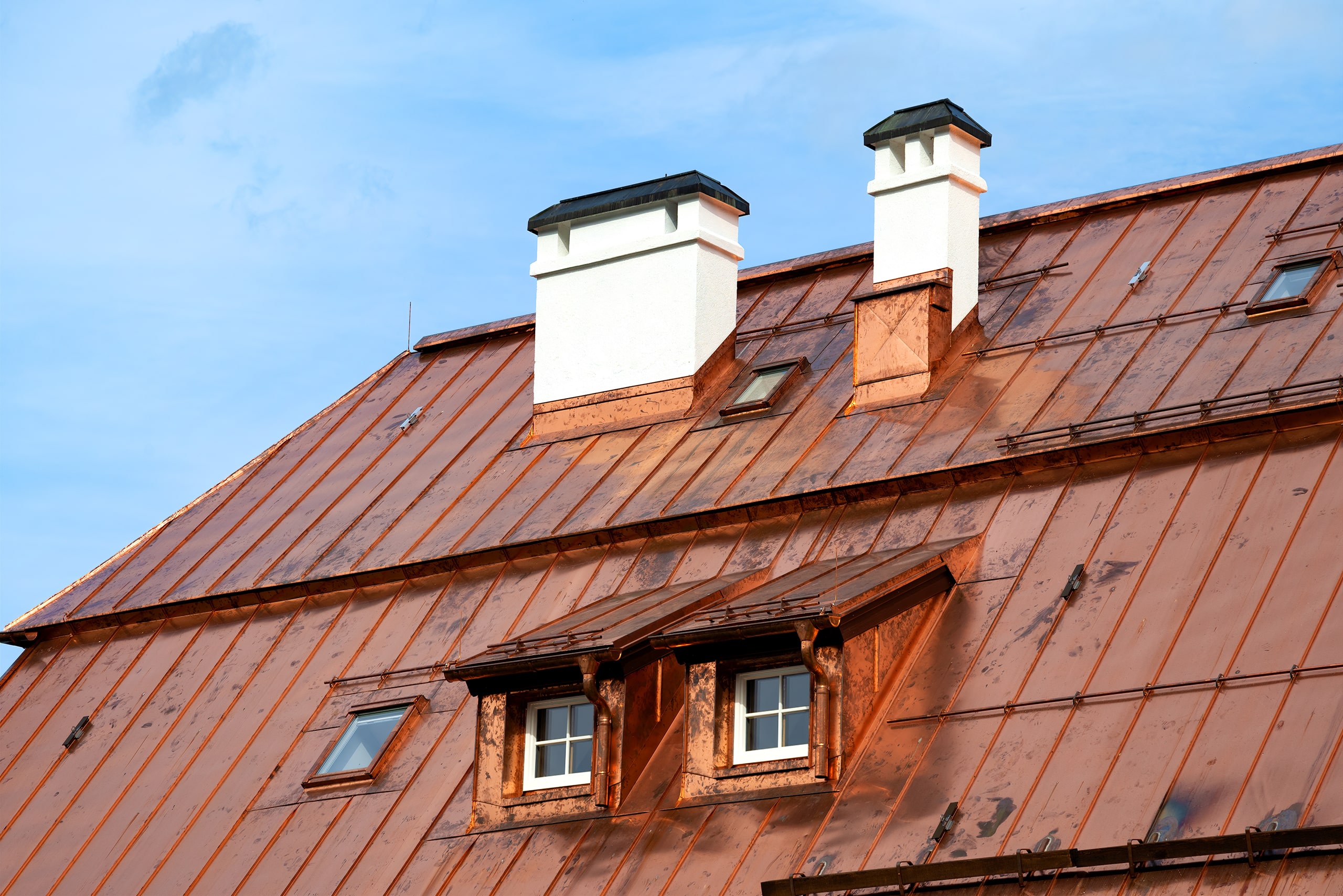 Nahaufnahme eines aufwendigen, großflächigen Kupferdaches, bei welchem auf Grund der Witterung die typische Oxidation eingesetzt hat.