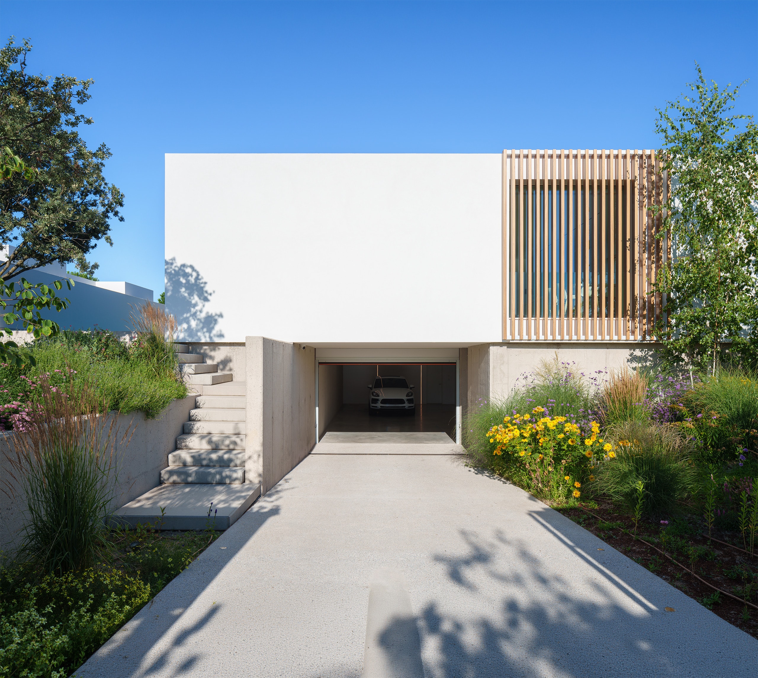 Modernes, weißes Flachdach-Haus in minimalistischem Design mit Pool, Design-Elementen, Einfahrtstor und üppigem Grün. - KI-generiert