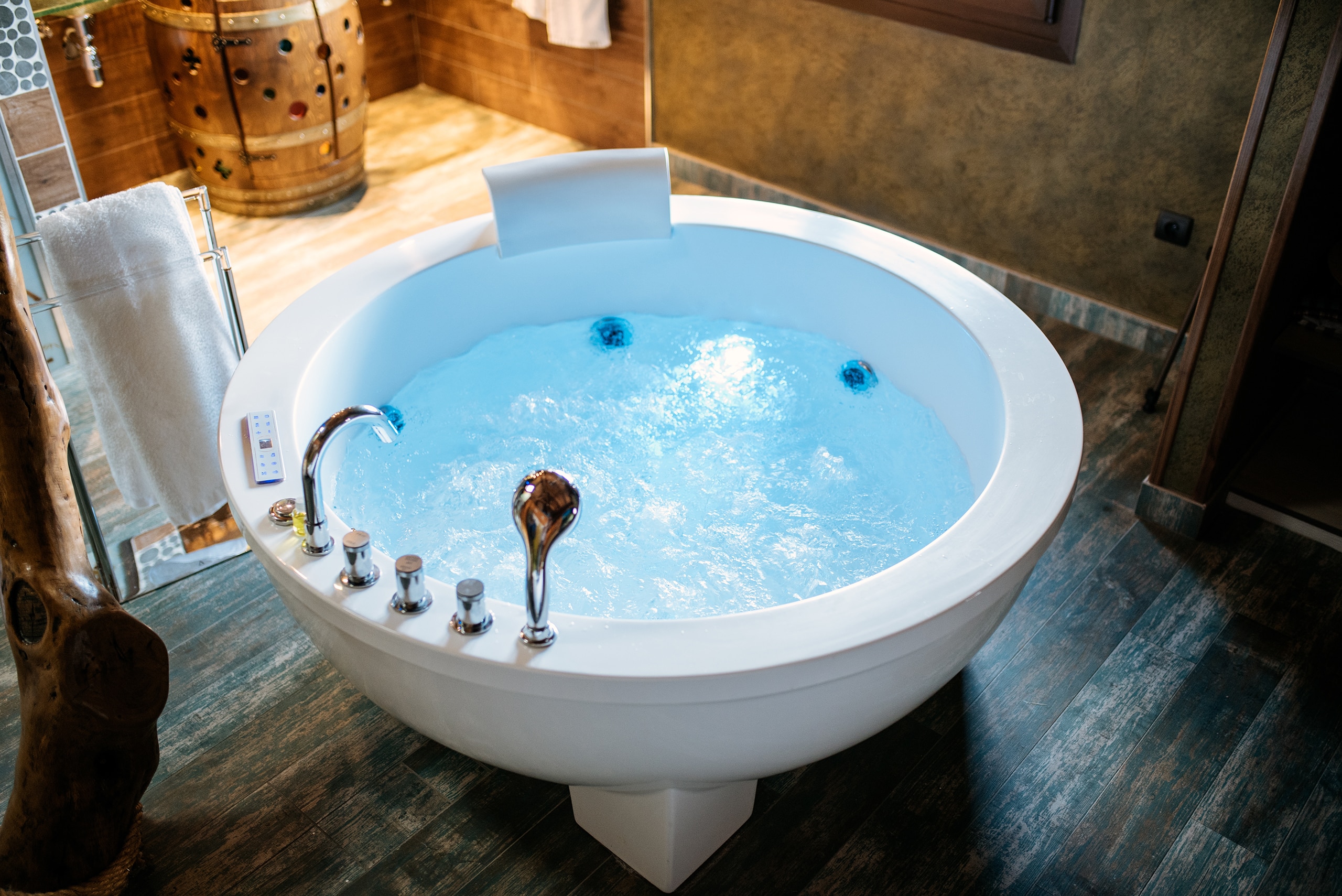 Moderner, freistehender Indoor-Whirlpool im runden Keramik-Style als Eyecatcher des Home Spa-Bereiches.