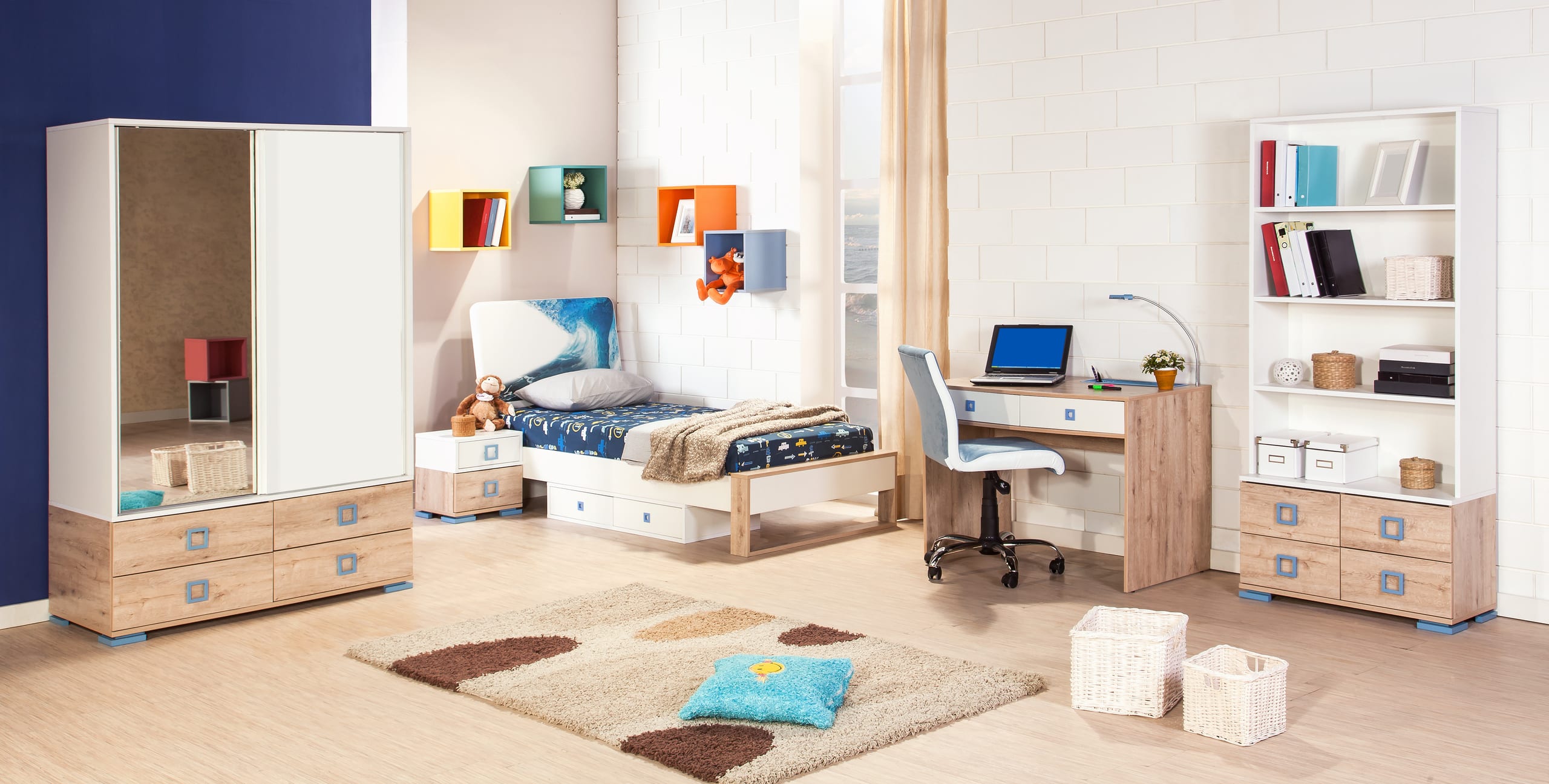 Helles Kinderzimmer, das mit Bett, Kleiderschrank, Schreibtisch, Bücherregal und bunten Wandboxen ausgestattet ist.