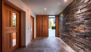Minimalistisch-modern gestalteter Eingangsbereich mit Holztüren und Steinwänden.