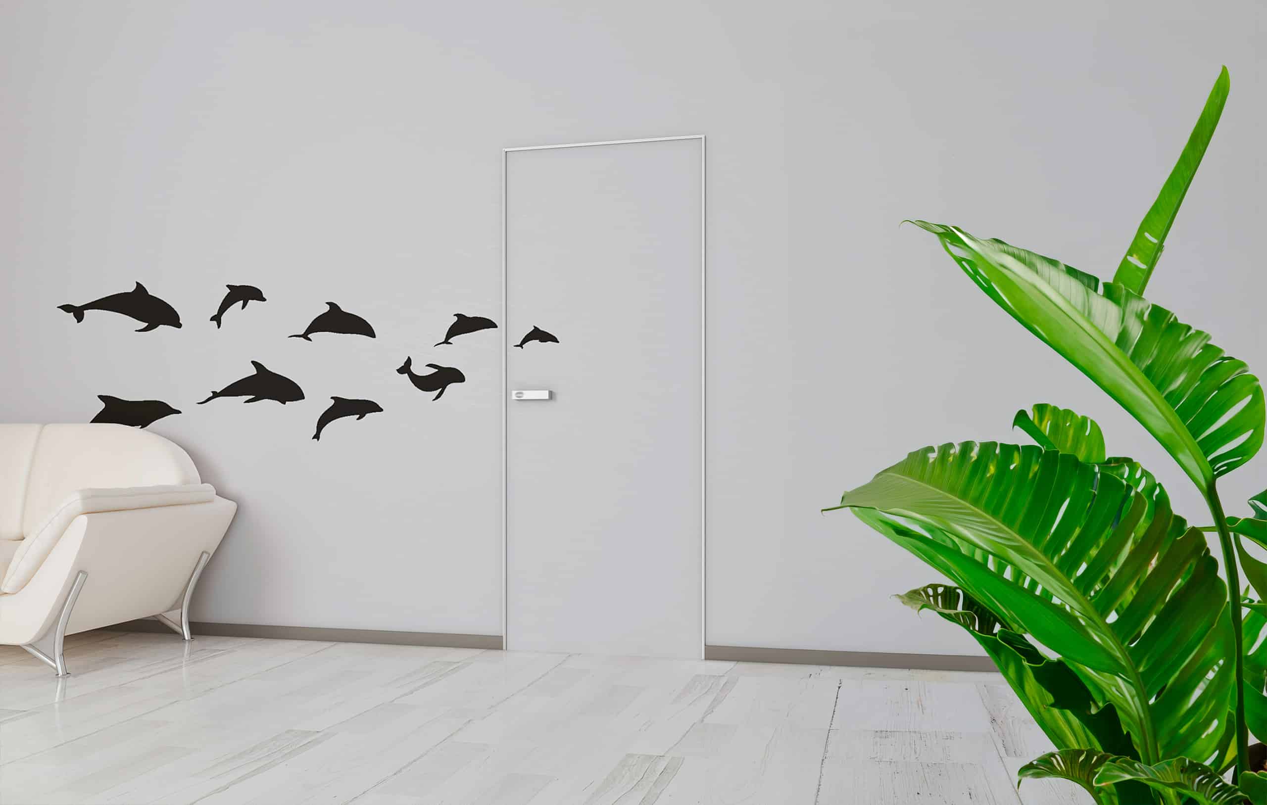 Heller, reduzierter Wohnraum mit einer wandbündigen Raumtür und Delphine in schwarz als Wandtatoo.