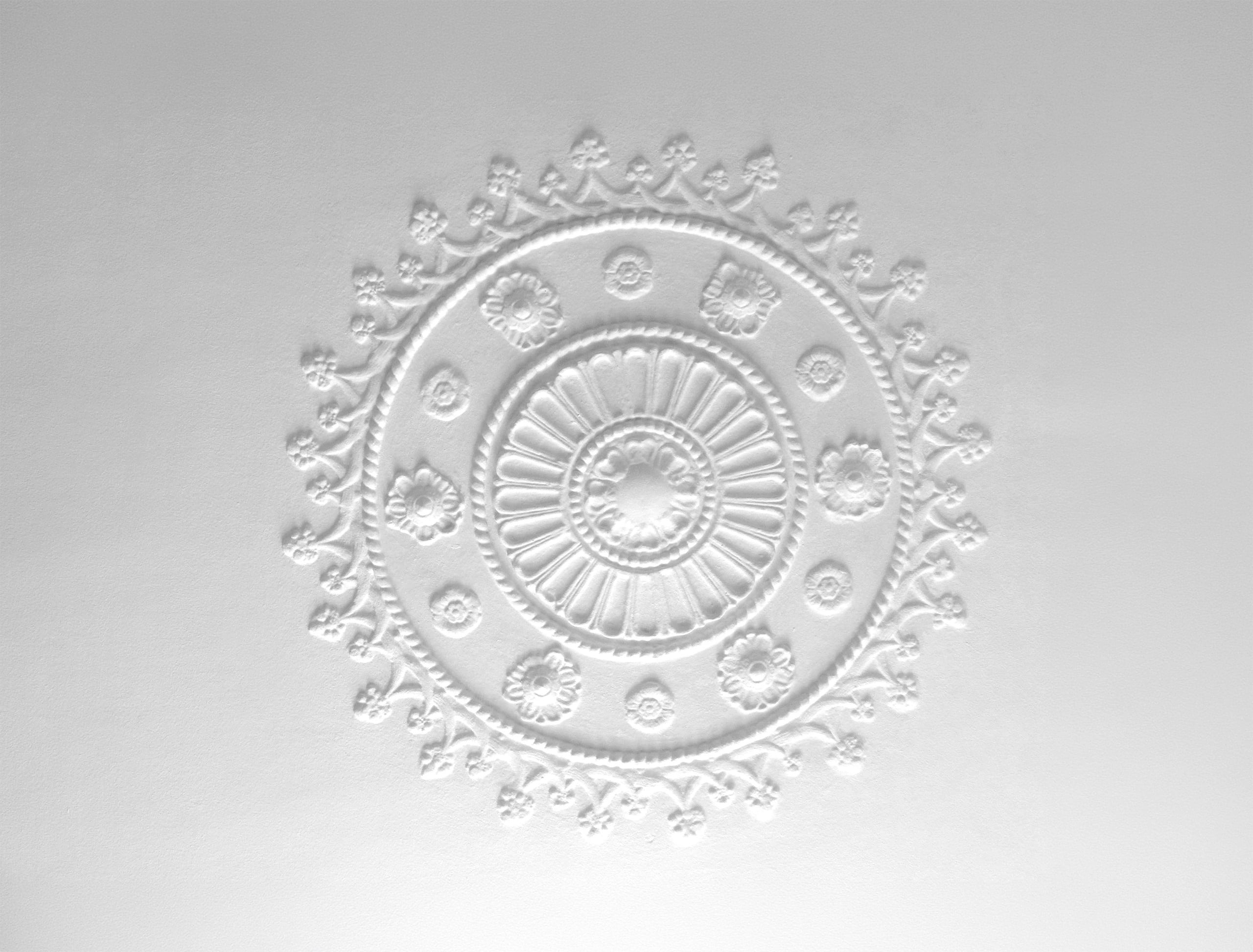 Aufwendig gestaltetes Stuckdesign in Form ein an der Decke einer gehobenen Altbauwohnung.