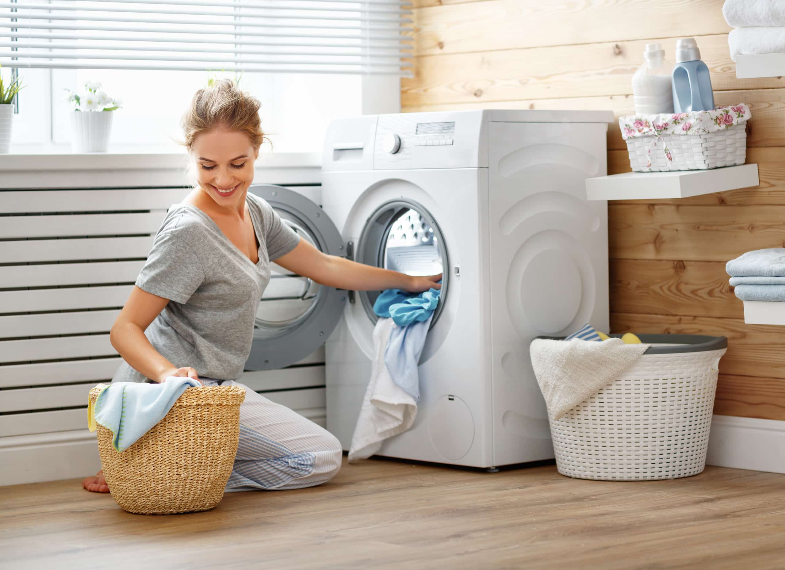 Frau befüllt eine Waschmaschine.