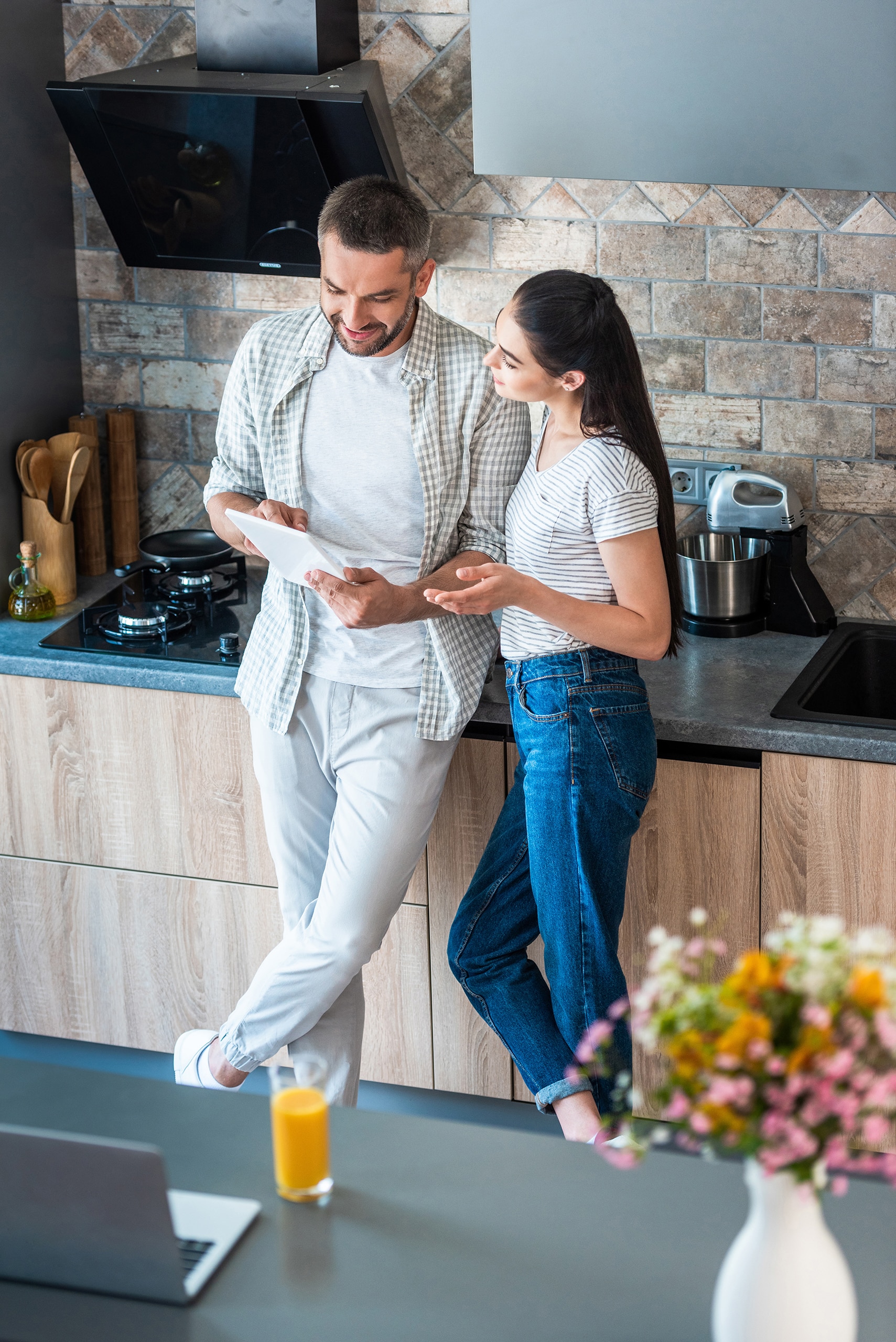 Ehepaar nutzt gemeinsam ein Tablet in der Küche – Smart-Home-Konzept