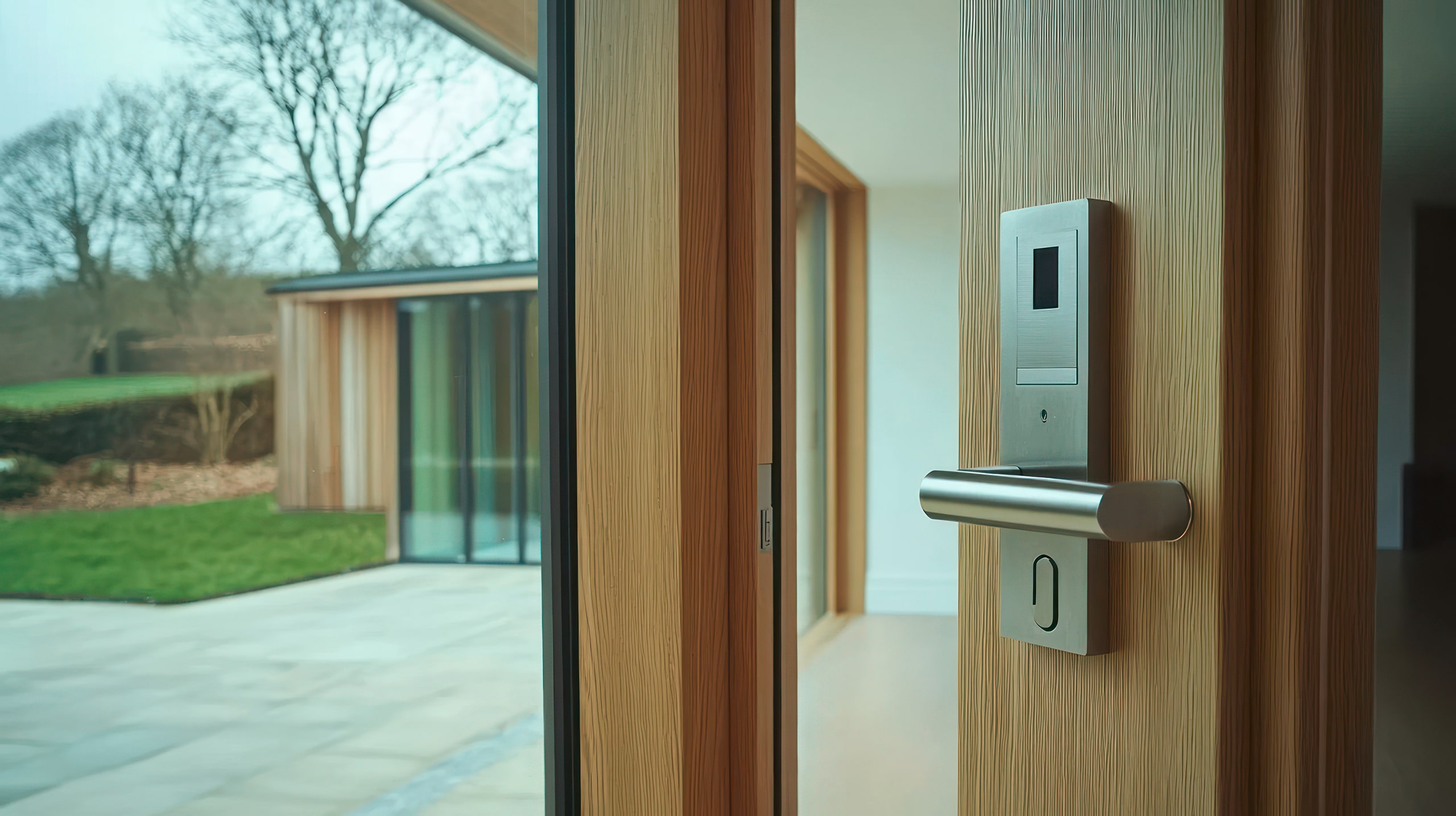 Moderne Holztür mit Fingerprint-Zugangsberechtigung und Blick auf den Garten.
