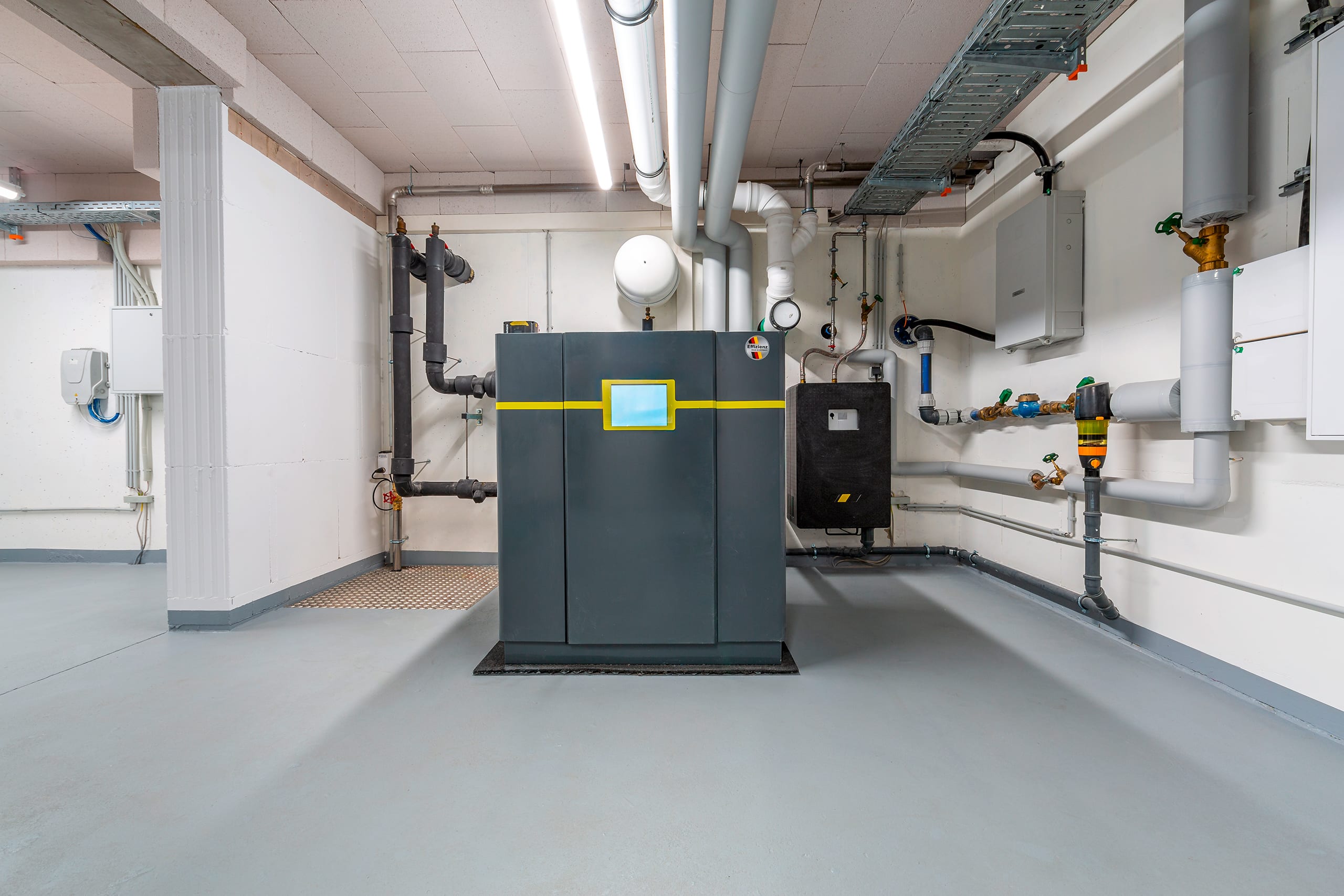 Moderne Heizungsanlage im Heizraumes eins Wohnhauses mit einer Erdwärme-Wärmepumpe.